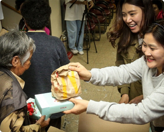 영진종합사회복지관에서 어르신께 버거를 전달하는 사진