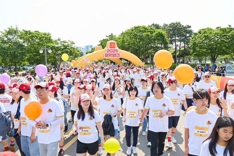 2025 맥도날드 해피워크 행사에서 참가자들이 풍선을 들고 걷는 모습으로, 가족과 함께하는 기부 캠페인을 표현