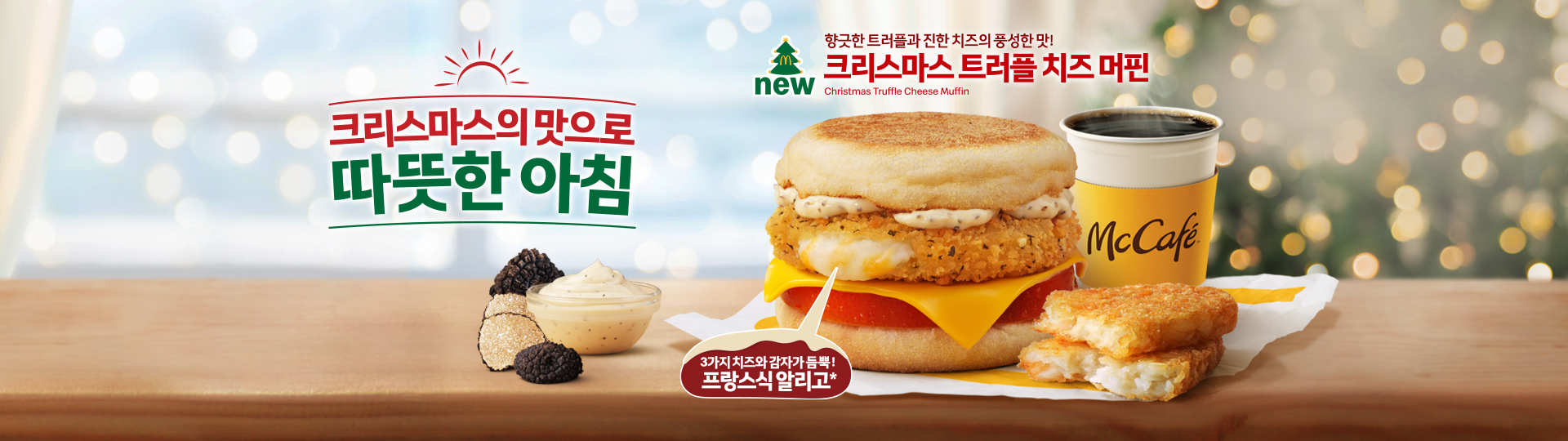 크리스마스 분위기의 배경 위에 맥도날드 ‘크리스마스 트러플 치즈 머핀’ 세트가 배치된 홍보 이미지. 트러플향 소스와 치즈, 토마토, 치즈 해시브라운 패티가 들어간 머핀과 함께 감자 해시브라운, 뜨거운 맥카페 커피가 나란히 놓여 있으며, 좌측에는 ‘크리스마스의 맛으로 따뜻한 아침’이라는 문구가 크게 표시됨