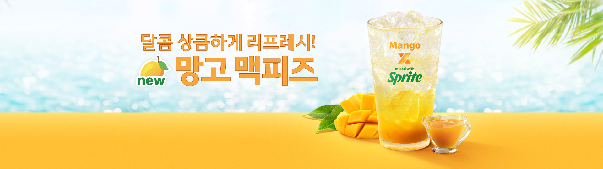 밝은 아침 햇살 느낌의 배경 위에, 바다를 연상시키는 블러 처리된 하늘색 그라데이션이 펼쳐져 있다.  화면 하단은 망고가 연상되는 노란 컬러의 톤으로 구성되어 있다.  중앙 좌측에는 “달콤 상큼하게 리프레시! 망고 맥피즈”라는 문구가 배치되어 있으며,  ‘망고’라는 단어 옆에는 망고 아이콘과 함께 ‘new’라는 표시가 추가되어 신제품임을 강조한다.  우측에는 투명한 컵에 담긴 음료가 중심 비주얼로 배치되어 있다. 컵 안에는 얼음이 가득 들어 있고, 아래쪽에는 진한 망고 색상의 시럽이 층을 이루며 위쪽의 투명한 탄산 음료와 자연스럽게 섞이고 있다.   컵 옆에는 잘 익은 망고가 먹기 좋게 깍둑 썰린 상태로 놓여 있으며, 망고 잎과 함께 배치되어 있다.  또한 작은 유리 소스컵에는 망고 시럽이 담겨 있다.
